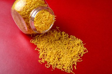 Hint baharatlı çerezi besan sev, diwali yemeği kırmızı arka planda.