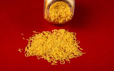 Hint baharatlı çerezi besan sev, diwali yemeği kırmızı arka planda.