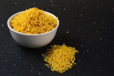 Hint baharatlı besan sev, diwali yemeği siyah arka planda.