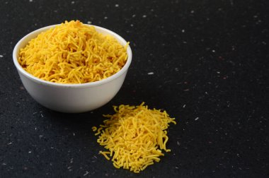 Hint baharatlı besan sev, diwali yemeği siyah arka planda.