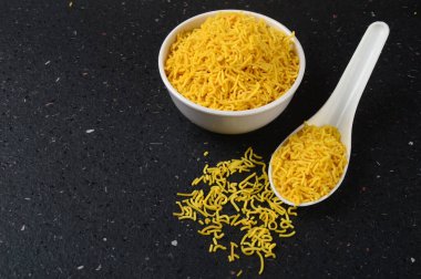 Hint baharatlı besan sev, diwali yemeği siyah arka planda.