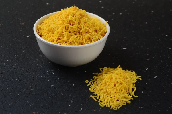 Hint baharatlı besan sev, diwali yemeği siyah arka planda.