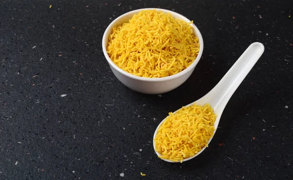 Hint baharatlı besan sev, diwali yemeği siyah arka planda.