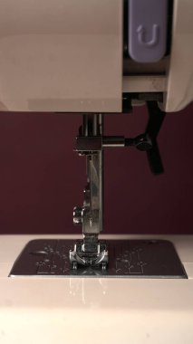 Masasında iplik ve kumaş olan modern dikiş makinesi.