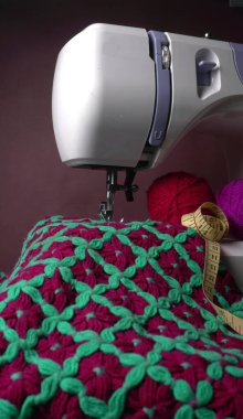 Masasında iplik ve kumaş olan modern dikiş makinesi.