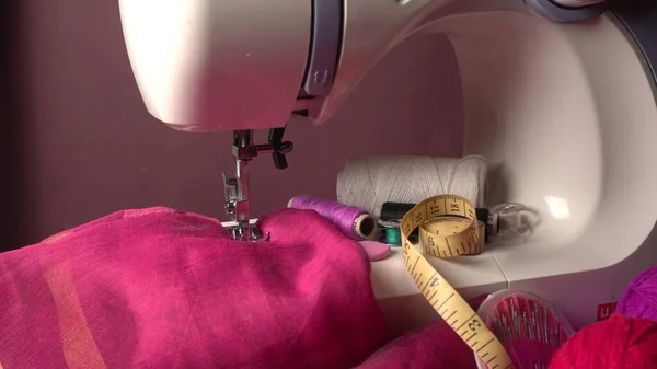 Masasında iplik ve kumaş olan modern dikiş makinesi.