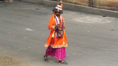 JAIPUR, RAJASTHAN, INDIA - 11 AĞUSTOS, 2019: Geleneksel elbise içinde yolda yürüyen kimliği belirsiz Hintli yaşlı adam.