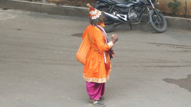 JAIPUR, RAJASTHAN, INDIA - 11 AĞUSTOS, 2019: Geleneksel elbise içinde yolda yürüyen kimliği belirsiz Hintli yaşlı adam.