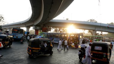 PUNE, Hindistan - 19 HAZİRAN 2020: Güzel bir altın gün batımı sırasında işlek sokaklarda günlük trafik ve şehir hayatı.