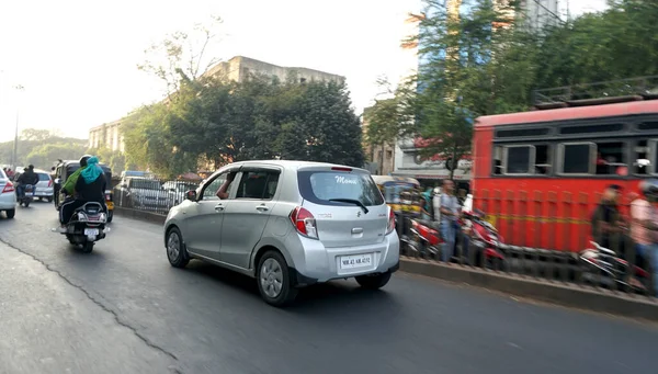 PUNE, Hindistan - 19 HAZİRAN 2020: Güzel bir altın gün batımı sırasında işlek sokaklarda günlük trafik ve şehir hayatı.