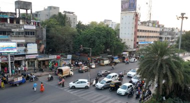PUNE, Hindistan - 19 HAZİRAN 2020: Güzel bir altın gün batımı sırasında işlek sokaklarda günlük trafik ve şehir hayatı.