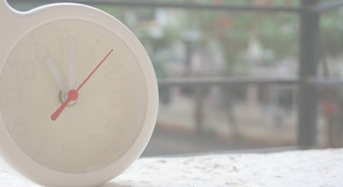 Beyaz bir saatin yakın plan çekimi ve zamanı gösteren oklar. 