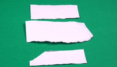 Yeşil arkaplana sıkışmış mesaj veya metin için beyaz kağıt parçaları.