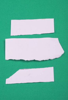 Yeşil arkaplana sıkışmış mesaj veya metin için beyaz kağıt parçaları.