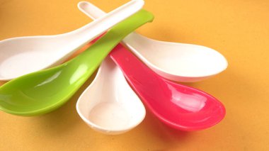 Renkli arkaplanda boş plastik kaşıklar