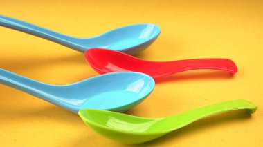 Renkli arkaplanda boş plastik kaşıklar