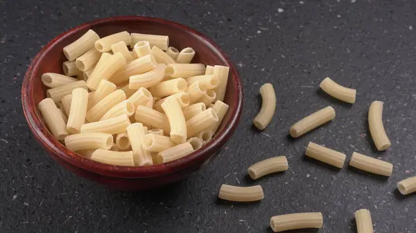 배경에 그릇에 Raw Penne 파스타 — 스톡 사진