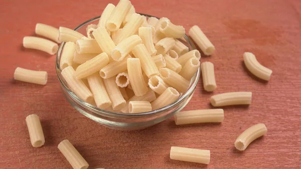 Pasta Penne Cruda Tazón Sobre Fondo Naranja —  Fotos de Stock