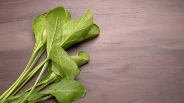 Ahşap arka planda taze ıspanak. Vejetaryen gıda yaşam tarzı konsepti, alanı kopyala.