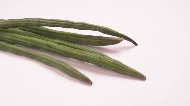 Davul bagetleri yakın çekim, soyulmuş bagetlerden bazıları. Bembeyaz arka planda sağlıklı sebzeler 