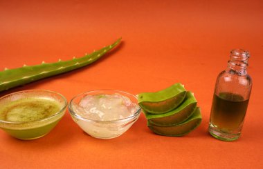 Aloe Vera 'nın dilimleri turuncu arka planda bir kasede duruyor. Aloe Vera cilt bakımı ve saç bakımı için çok faydalı bir bitkisel ilaçtır.