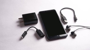 OTG tipi C ve siyah cep telefonu, kulaklık ve dış ses kartı beyaz arkaplanda izole edilmiş. .