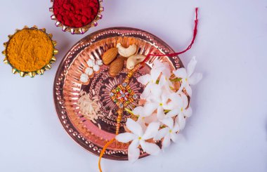 Hint Festivali: Rakhi, pirinç taneleri, kumkum, tatlılar ve şık bir Rakhi tabağında diya. Geleneksel Hint bilekliği Kardeşler ve Kız Kardeşler arasındaki aşkın sembolüdür.