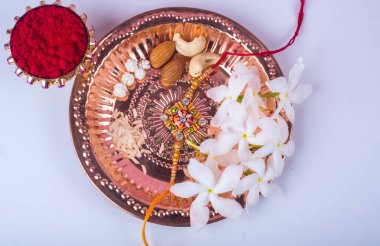 Hint Festivali: Rakhi, pirinç taneleri, kumkum, tatlılar ve şık bir Rakhi tabağında diya. Geleneksel Hint bilekliği Kardeşler ve Kız Kardeşler arasındaki aşkın sembolüdür.