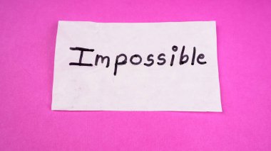 Kendini motive etme konsepti. Beyaz kağıda pembe arkaplan üzerine imkansız sözcük yaz