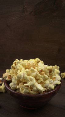 Tahta arka planda patlamış mısırla yakın plan. 