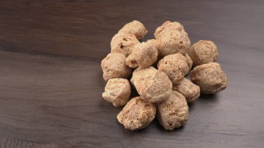 Ahşap zemin üzerinde çiğ soya parçaları yığını. Sağlıklı, besleyici soya eti, masada parçalar. Vejetaryen gıda konsepti.