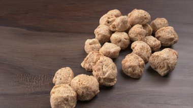 Ahşap zemin üzerinde çiğ soya parçaları yığını. Sağlıklı, besleyici soya eti, masada parçalar. Vejetaryen gıda konsepti.