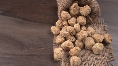 Ahşap zemin üzerinde çiğ soya parçaları yığını. Sağlıklı, besleyici soya eti, masada parçalar. Vejetaryen gıda konsepti.