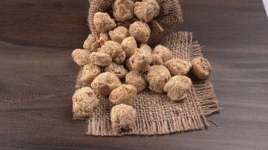 Ahşap zemin üzerinde çiğ soya parçaları yığını. Sağlıklı, besleyici soya eti, masada parçalar. Vejetaryen gıda konsepti.