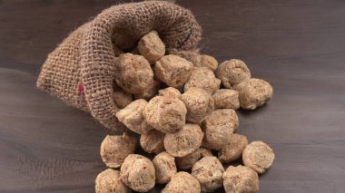 Ahşap zemin üzerinde çiğ soya parçaları yığını. Sağlıklı, besleyici soya eti, masada parçalar. Vejetaryen gıda konsepti.