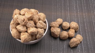 Ahşap zemin üzerinde çiğ soya parçaları yığını. Sağlıklı, besleyici soya eti, masada parçalar. Vejetaryen gıda konsepti.