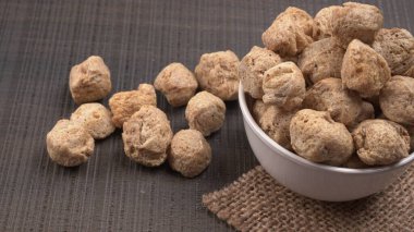 Ahşap zemin üzerinde çiğ soya parçaları yığını. Sağlıklı, besleyici soya eti, masada parçalar. Vejetaryen gıda konsepti.