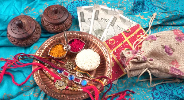 Pile of Indian Money With Traditional Indian Bracelet Calls Rakhi, Sister Ties On Brothers Wrist on the Ocassion of Raksha bandhan