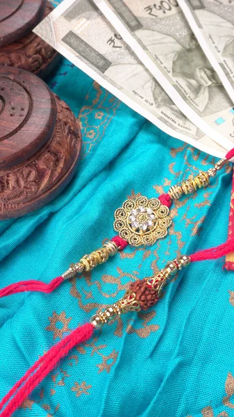 Pile of Indian Money With Traditional Indian Bracelet Calls Rakhi, Sister Ties On Brothers Wrist on the Ocassion of Raksha bandhan