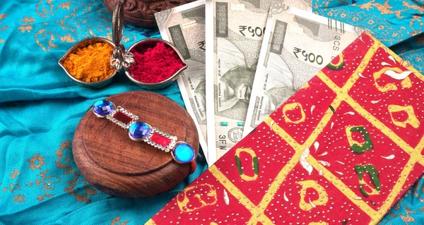 Pile of Indian Money With Traditional Indian Bracelet Calls Rakhi, Sister Ties On Brothers Wrist on the Ocassion of Raksha bandhan