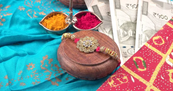 Pile of Indian Money With Traditional Indian Bracelet Calls Rakhi, Sister Ties On Brothers Wrist on the Ocassion of Raksha bandhan