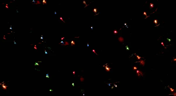 黒の背景に燃えるクリスマスライト 抽象的な背景 — ストック写真