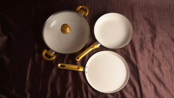 褐色布底上有陶瓷的金油锅 — 图库照片