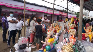 PUNE, Hindistan - 5 Mayıs 2020: CORONA VIRUS MEDICAL MASK giyen bir Hintli Hindistan 'daki tecrit sırasında temel ihtiyaç maddelerini alırken COVID-19 CORONAVIRUS' u önlemek için.