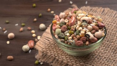 Ahşap arka planda çeşitli fasulye yığınları. Sağlıklı gıda konsepti