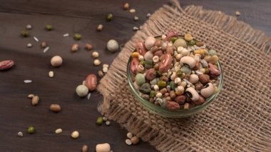 Ahşap arka planda çeşitli fasulye yığınları. Sağlıklı gıda konsepti