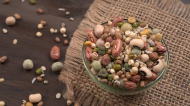 Ahşap arka planda çeşitli fasulye yığınları. Sağlıklı gıda konsepti