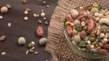 Ahşap arka planda çeşitli fasulye yığınları. Sağlıklı gıda konsepti