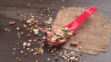 Ahşap arka planda çeşitli fasulye yığınları. Sağlıklı gıda konsepti