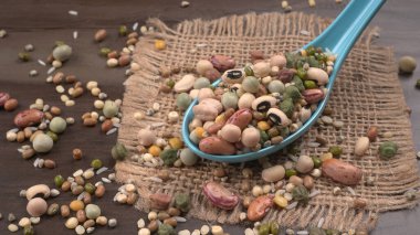 Ahşap arka planda çeşitli fasulye yığınları. Sağlıklı gıda konsepti